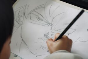 Child drawing anime character with pencil on paper